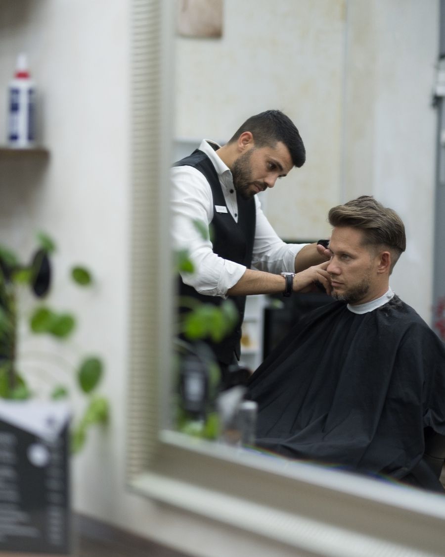 Barbier bei der Arbeit, im Spiegel gesehen