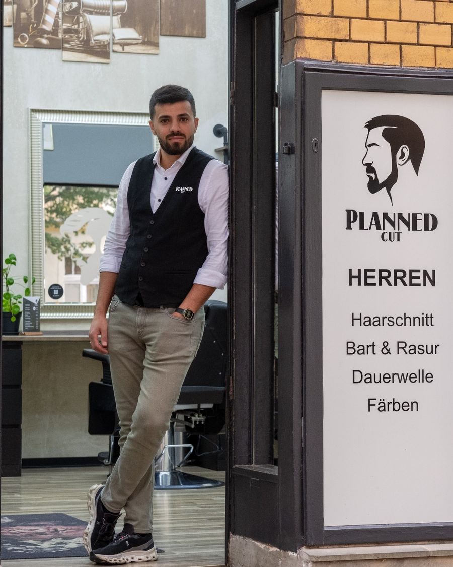 Barbier in Weste im Eingang des Ladens